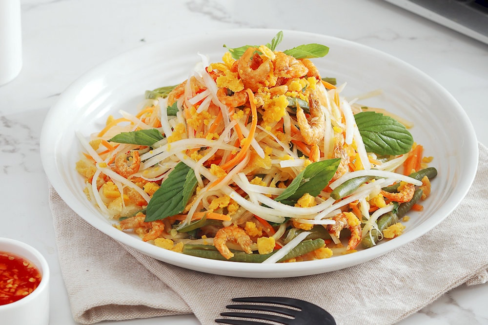 Papaya salad, with a blend of sweet, sour, spicy, and salty flavors and crunchy papaya, brings an explosion of attractive flavors